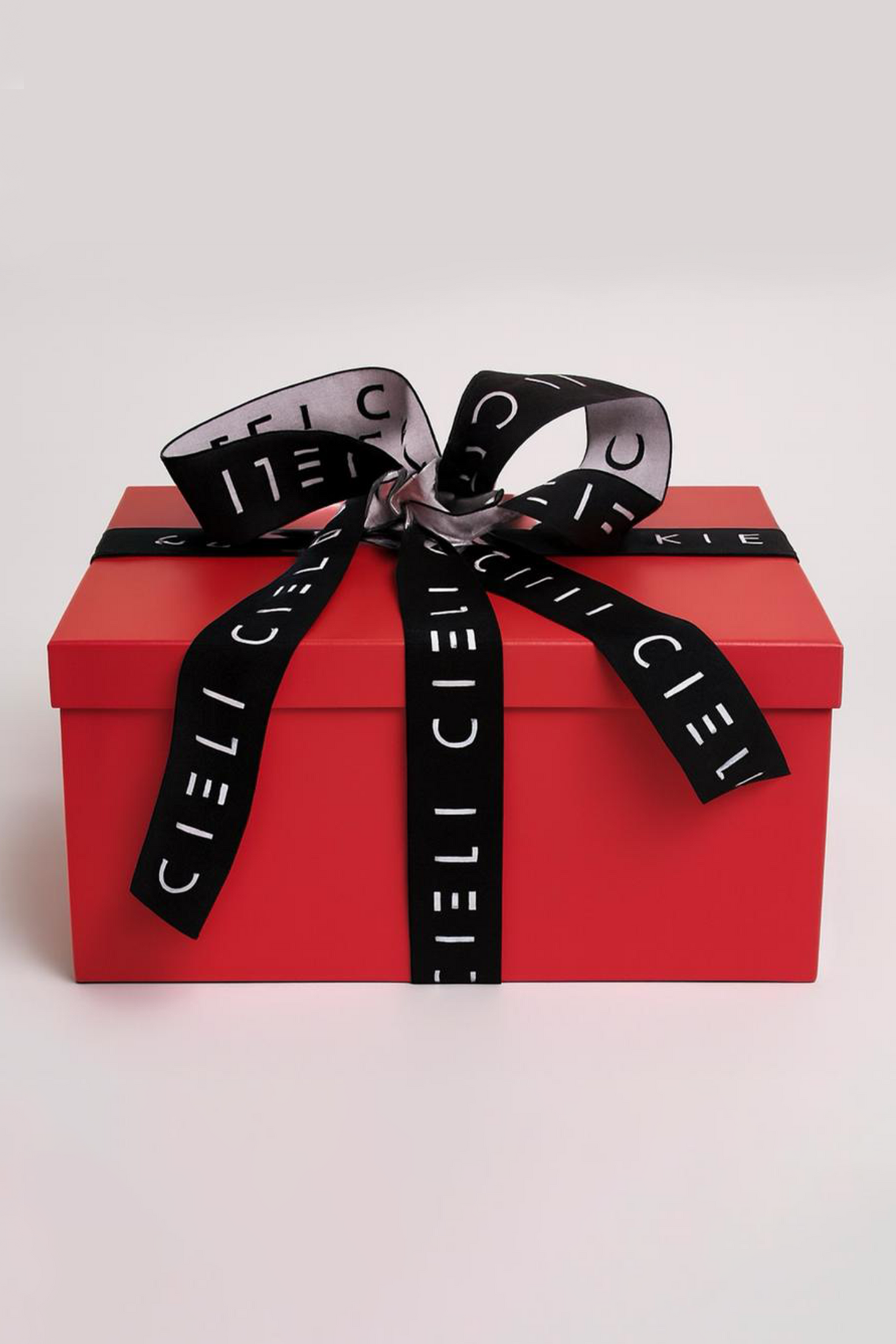 Red gift box with a black ribbon featuring 'Cieli' on a light gray background