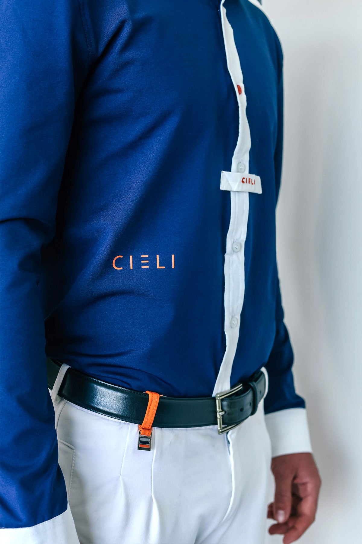 Person wearing a blue and white shirt with 'CIELI' branding on a plain background