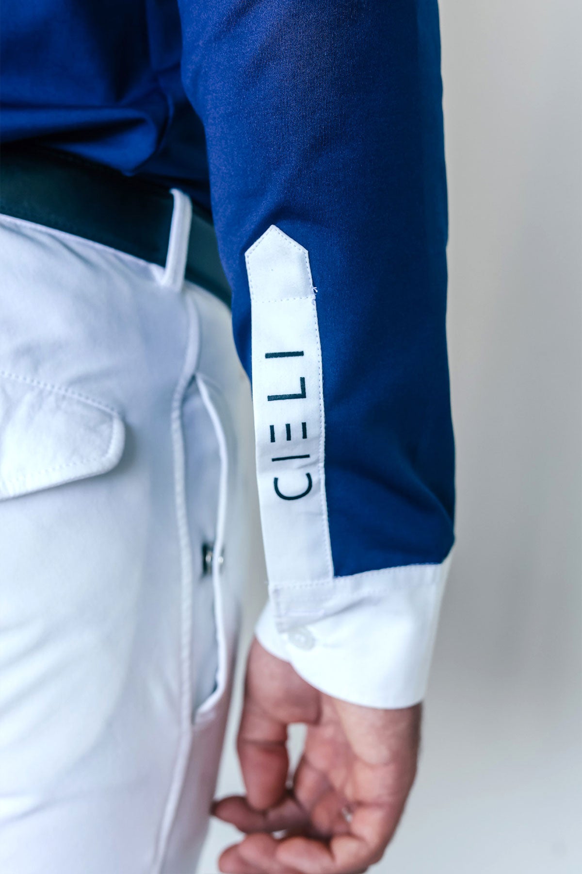 Close-up of a person wearing a blue long-sleeve shirt with 'CIELI' branding on the sleeve.