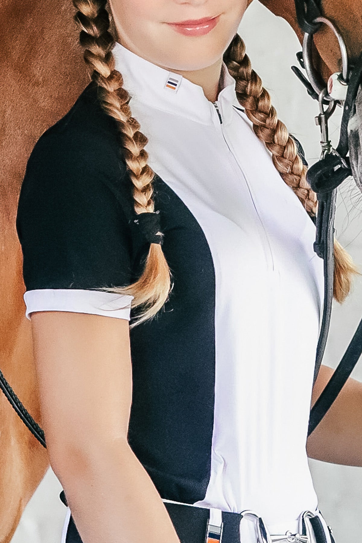 Girl wearing a short sleeve cieli equestrian show shirt in black and white with UV protection.