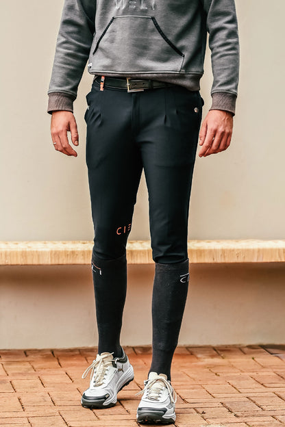 Person wearing black pants and a gray hoodie standing on a wooden floor.