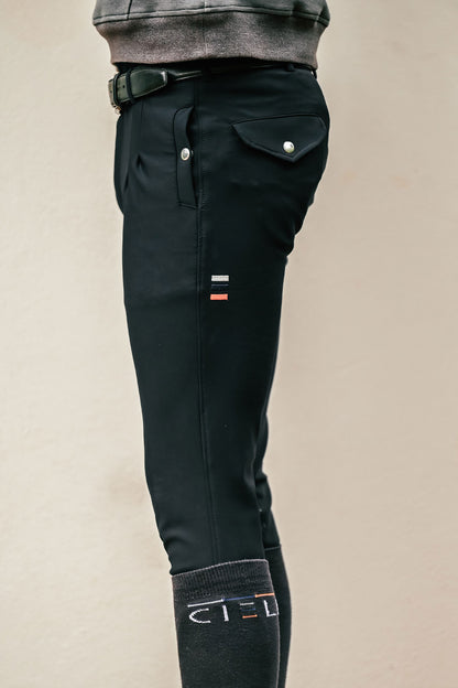 Black riding pants with brand logo on a beige background