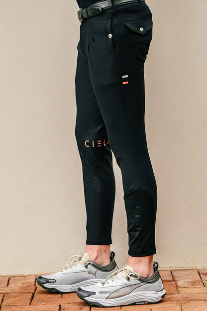 Person wearing black pants with visible branding on a beige background