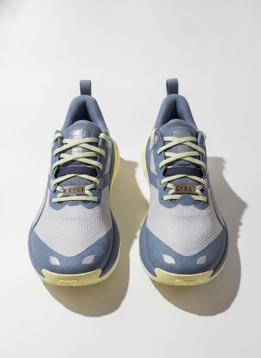 A pair of Puma sneakers in light blue, white, and pale yellow, shown from a top-down angle on a light gray background.