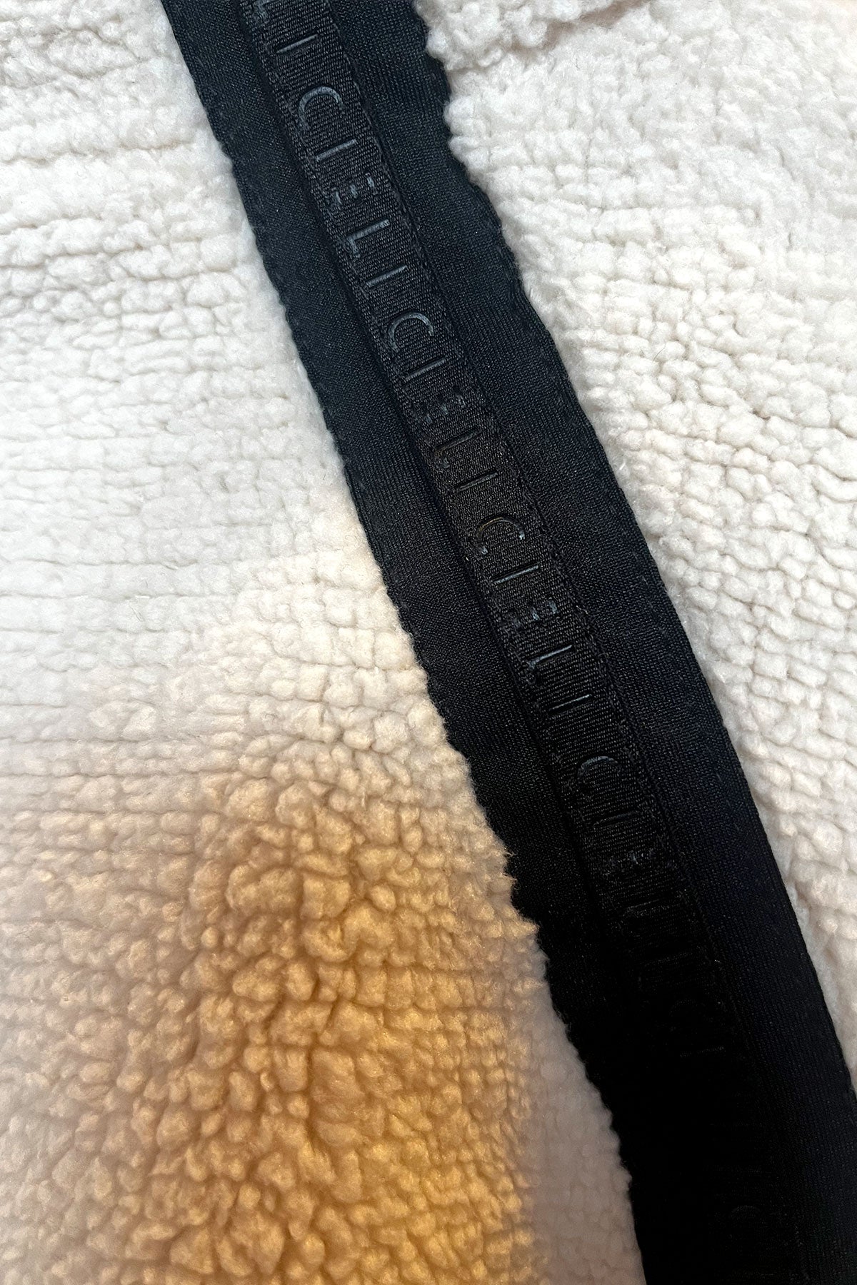 Close-up of a black zipper on a textured white and brown fabric background